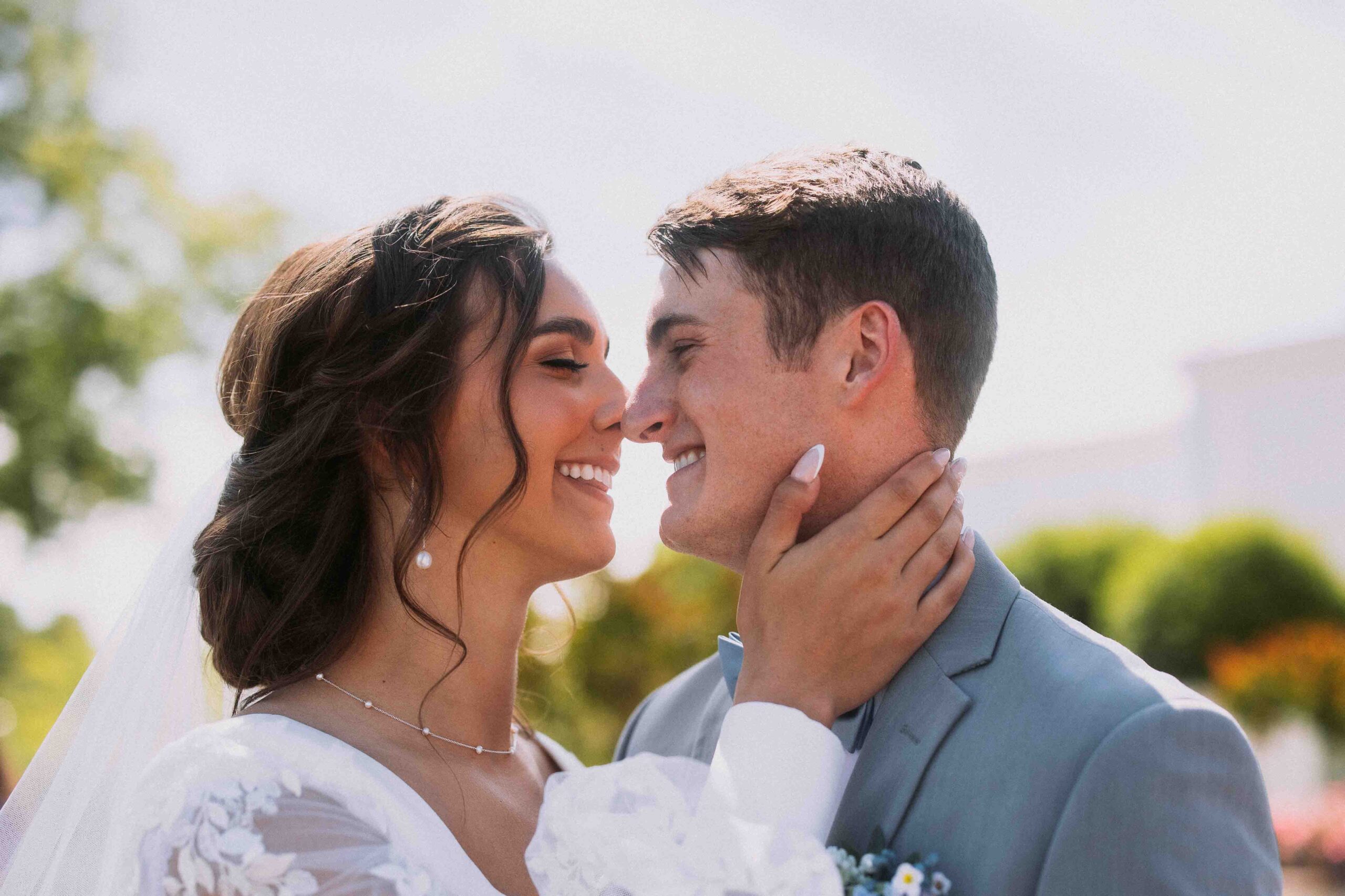 lds bride and groom kissing on a sunny day in st george utah at the st george temple of the church of jesus christ of latter day saints