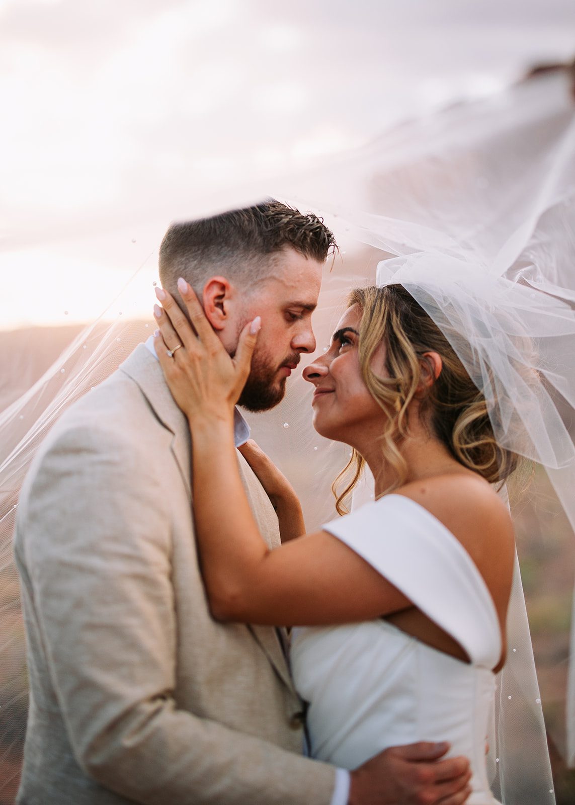 bride and groom looking into each others eyes at golden hour in moab utah at red earth venue