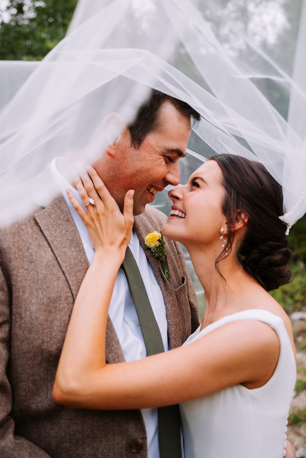 bride and groom sharing a laugh during a portrait session in the mountains of utah surrounded by pine trees near jordan pines utah