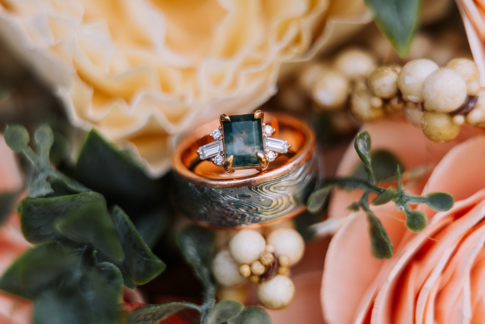 close up details of a mossy agate wedding ring with rose gold and diamonds in a meteorite mens wedding band for a wedding day detail photo
