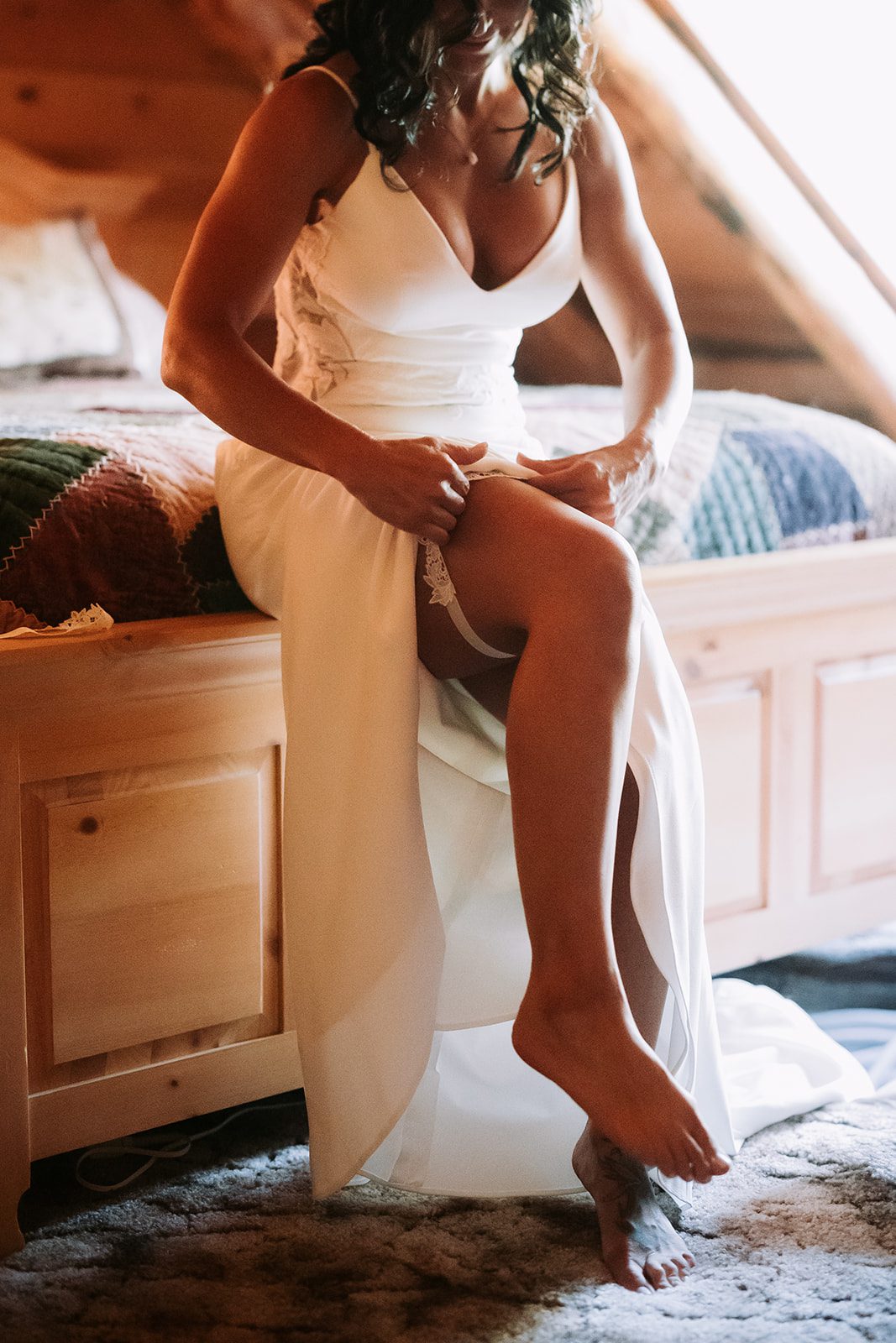 bride getting ready by putting on lage garter in a cabin at a private intimate elopement in utah